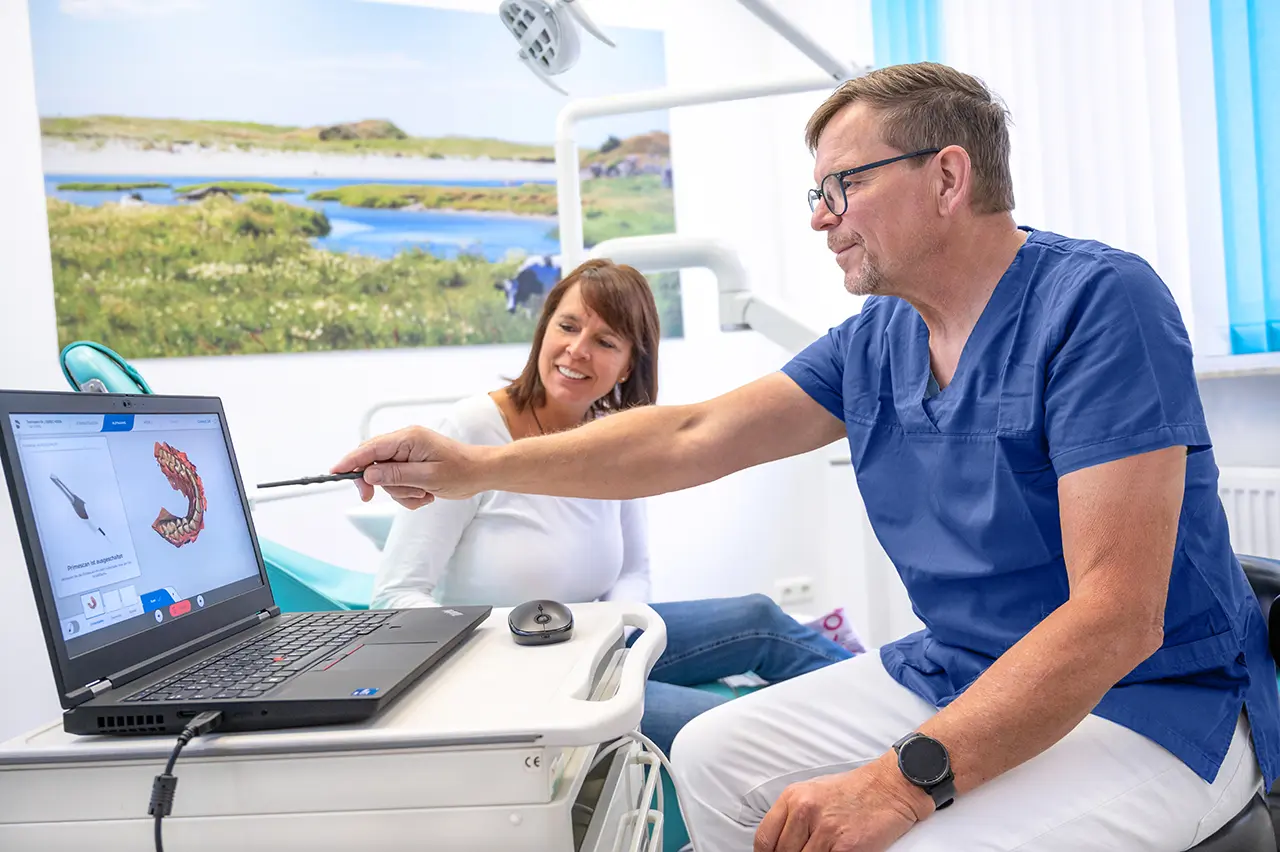 Zahnarzt erklärt Patientin die Behandlung